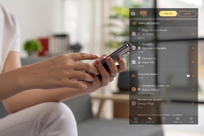 Hands of Woman Holding Phone on Sofa with 888sport Mobile Screenshot